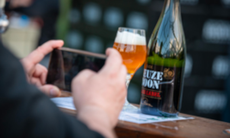 Man maakt foto van bierfles en glas